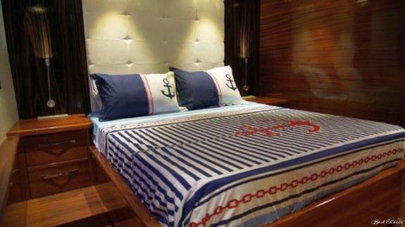 Luxurious bedroom with maritime bed linen on the 6-cabin gulet Şadiye Hanım in Marmaris.